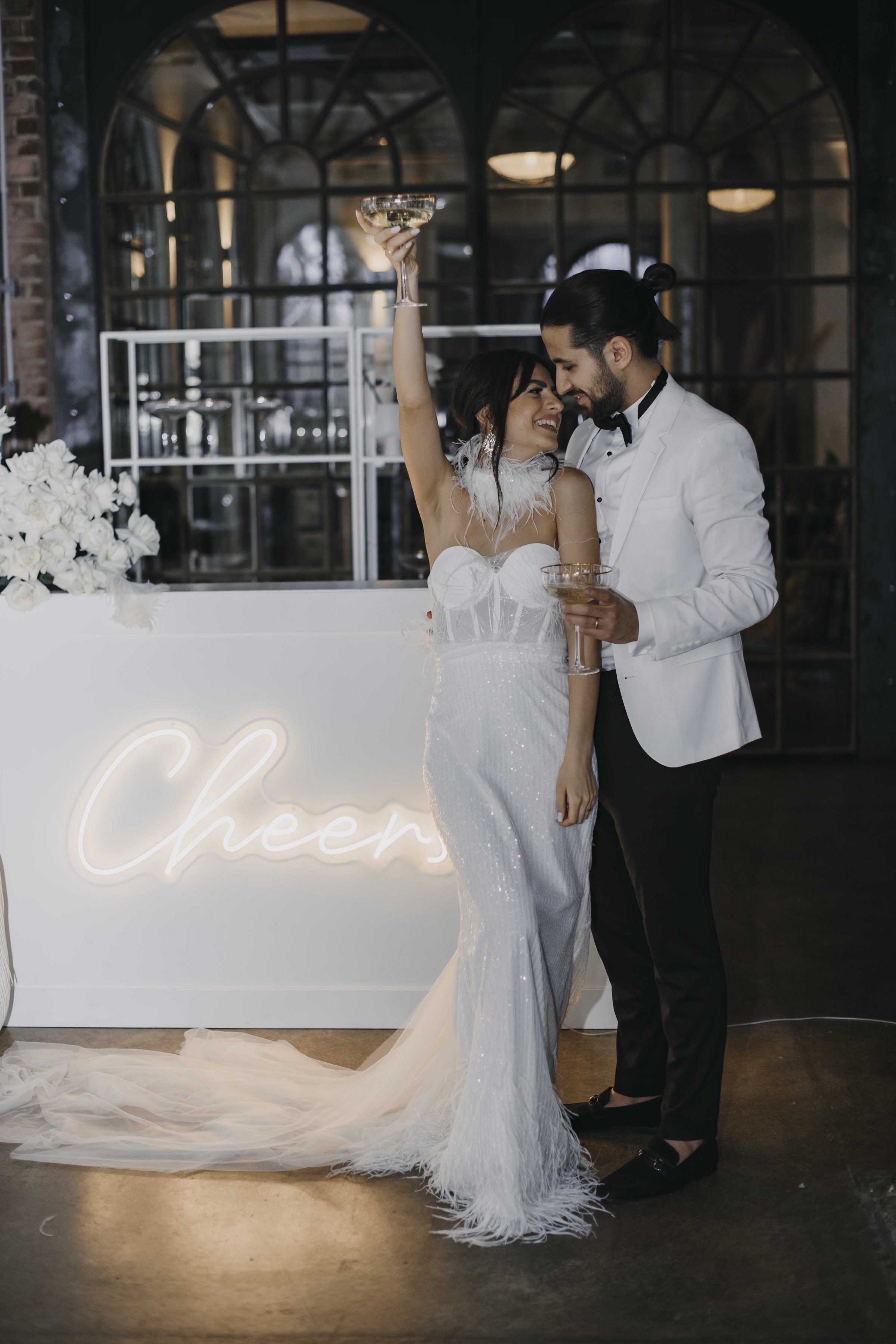 Couple celebrating at neon bar – luxury wedding reception photography Saphir Weddings